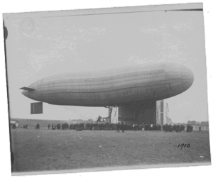 1910 - Luftschiff Parseval vor der Luftschiffhalle in Bickendorf umringt von Zuschauern.